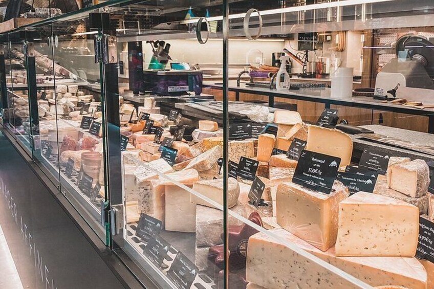 A cheese display with various types of cheese in a glass case. 4
