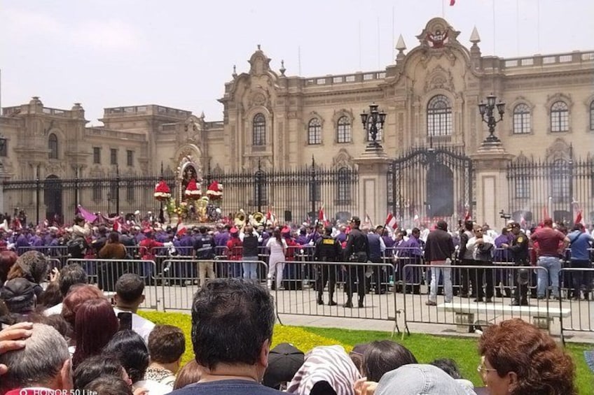 A crowd gathered in front of a historic building with ornate architecture. 2