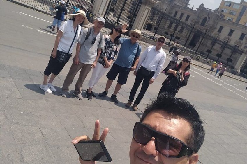 A group of people standing in a public square with historical buildings in the background. 5