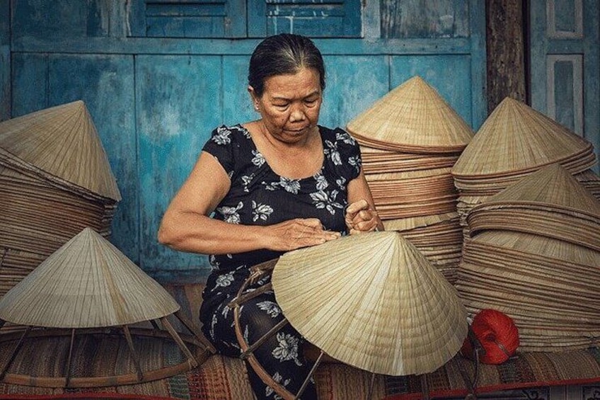 A person crafting traditional conical hats, surrounded by materials and tools. 2