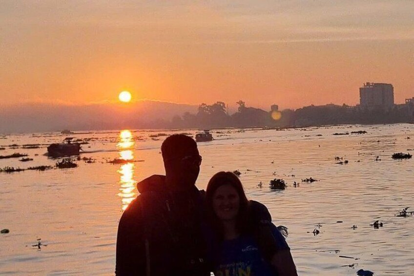 A sunset over a body of water with boats and a city skyline in the background. 5