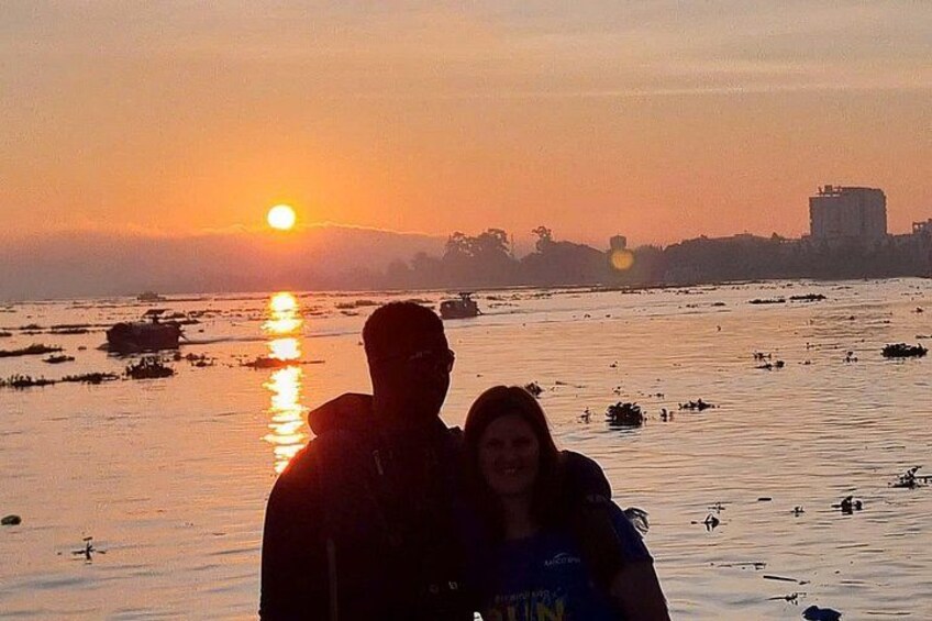 A sunset over a body of water with boats and a city skyline in the background. 5