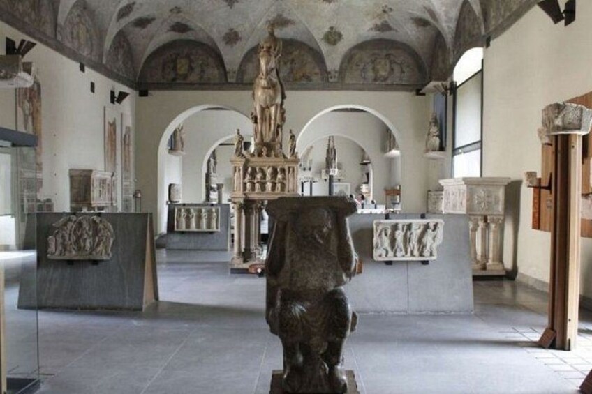 Un interior con arquitectura clásica, que presenta una estatua central, arcos y esculturas clásicas. 2