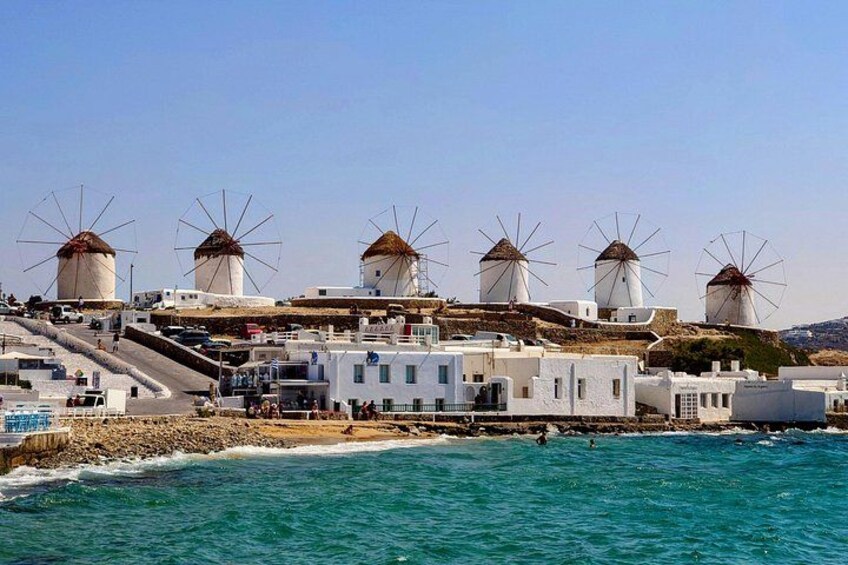Windmills, white buildings, and a coastline. 5