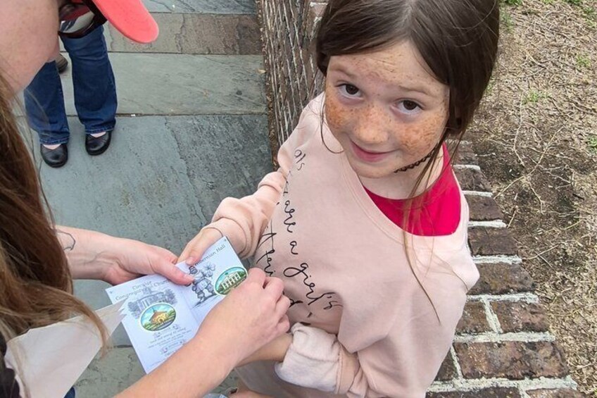 A person handing a document to a child. 5