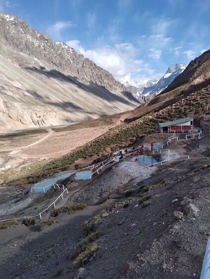 A mountainous landscape with a small building and a series of pools. 4