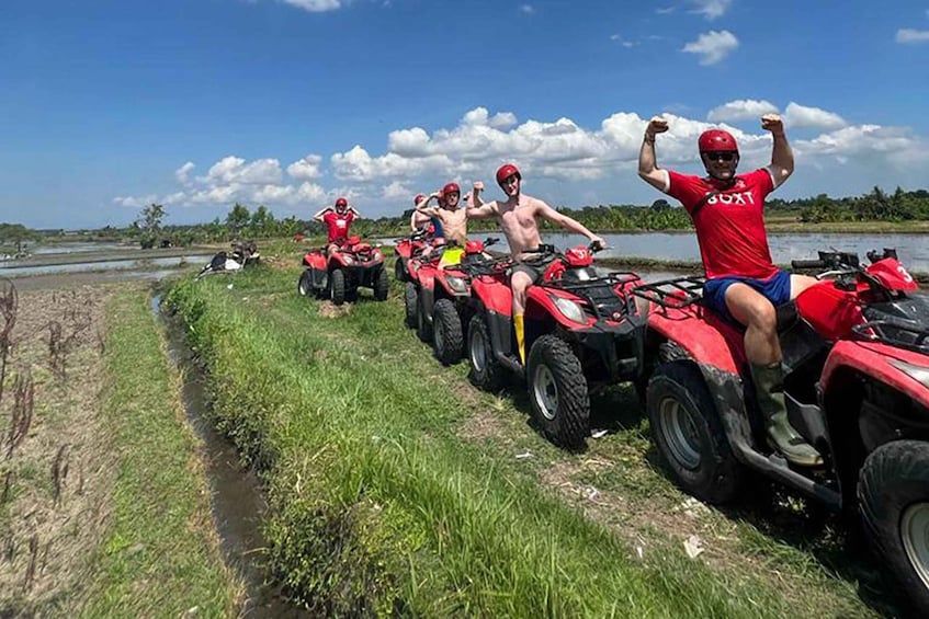 A group of people on ATVs near a body of water with a clear sky. 4