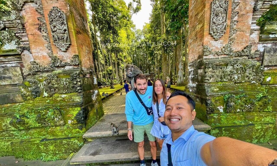 Ryhmä ihmisiä ottaa selfien muinaisten kivirakennusten edessä. Rakennuksissa on monimutkaisia kaiverruksia, ja niiden lähellä kulkee kapea vesiväylä. 2