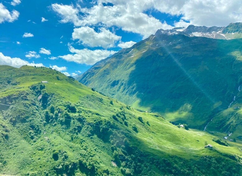 A mountainous landscape with lush green hills and a clear blue sky. 5