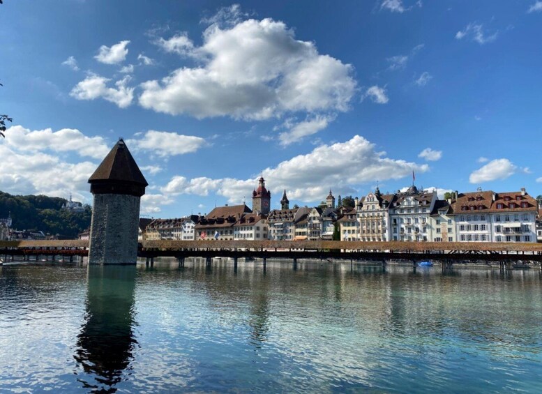 A river with a tower, a bridge, and historic buildings under a clear sky. 2