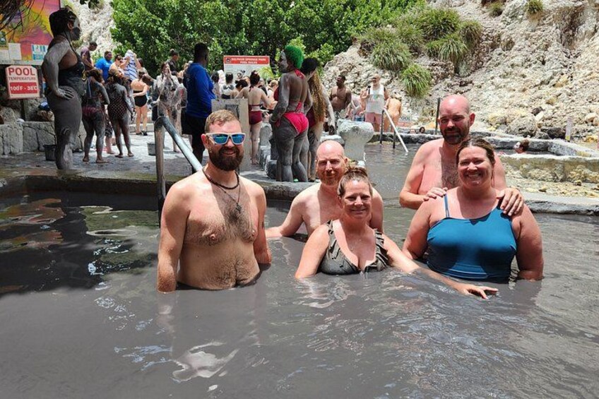 Un groupe de personnes se trouve dans une source d’eau chaude naturelle, avec un paysage rocheux en arrière-plan. 2