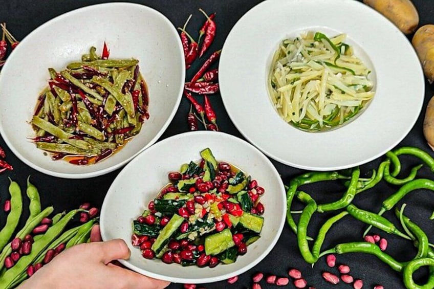 Three bowls of food with green vegetables and red chili peppers. 1