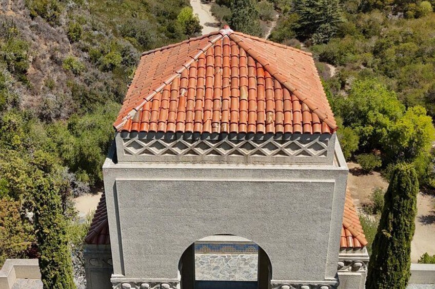 A building with a red-tiled roof and a stone facade. 5