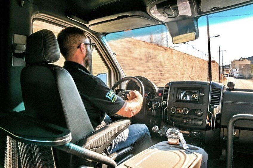 Eine Person fährt ein Fahrzeug mit Lenkrad, Armaturenbrett und einem Sitz für den Beifahrer. 1