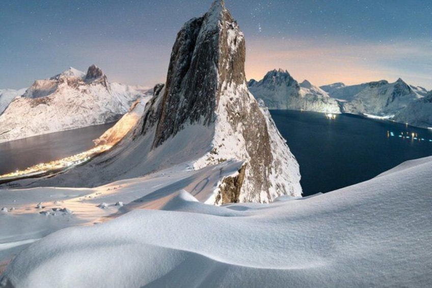 A snow-covered mountain peak with a lake in the background. 4