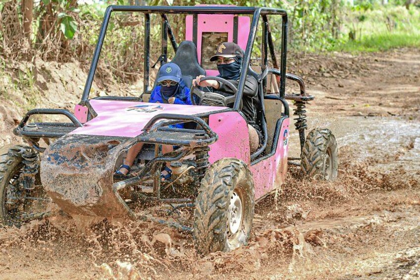 A pink off-road vehicle navigating through muddy terrain. 3
