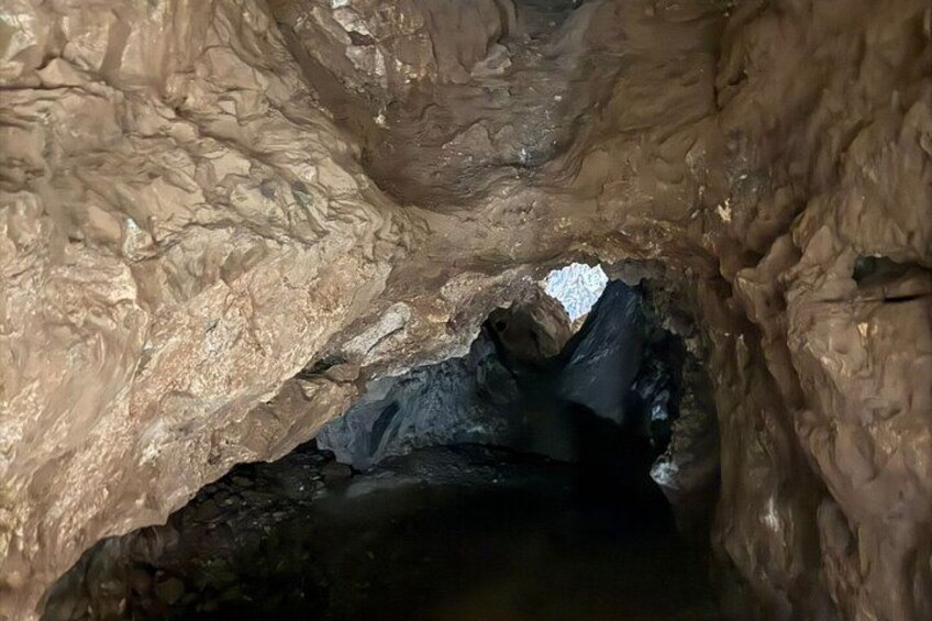 En grotta med steniga väggar och en synlig vattenpöl. 2