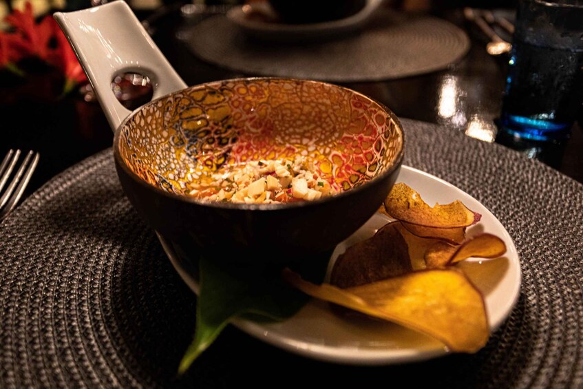 A bowl of soup with a patterned bowl and a plate with chips. 5