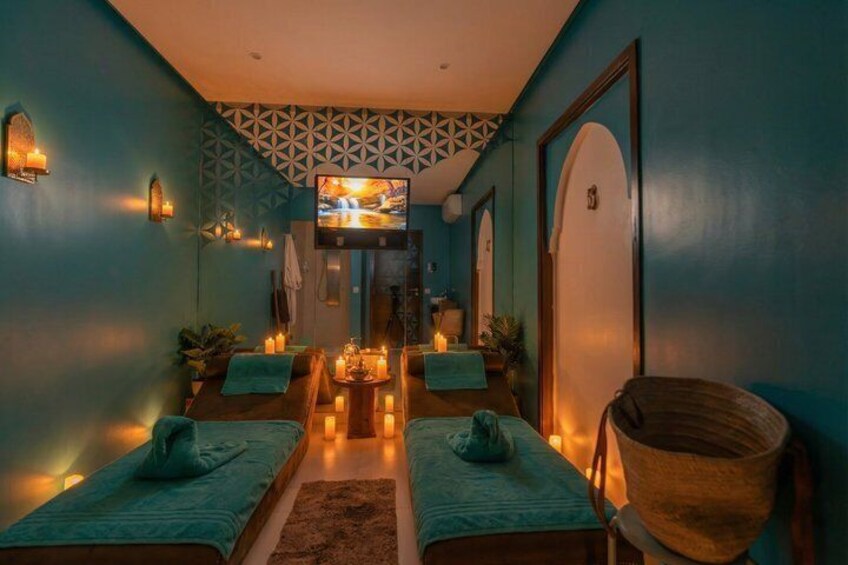 Une salle de spa équipée de deux tables de massage, de bougies et d’un téléviseur. 4
