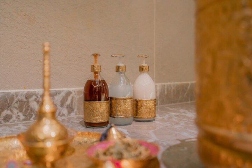 Une salle de bain avec trois flacons de savon liquide et un objet décoratif doré posé sur le comptoir. 3