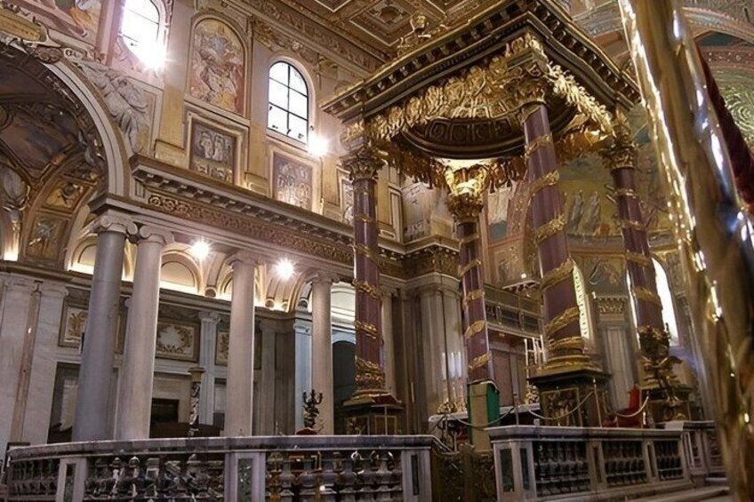 Un interior ornamentado con columnas, arcos y frescos detallados. 4