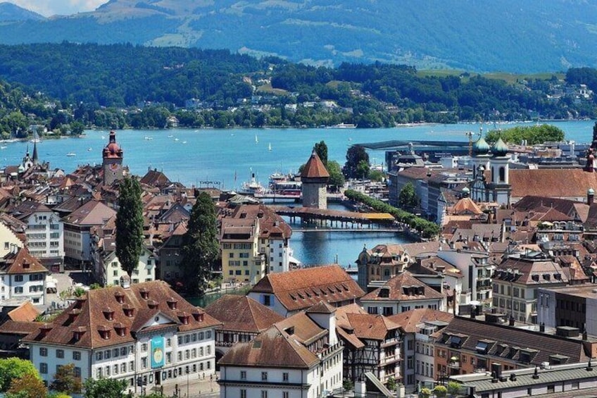 Vista panorámica de un pueblo a orillas del lago, con edificios históricos, una torre destacada y una imagen clara del lago. 2