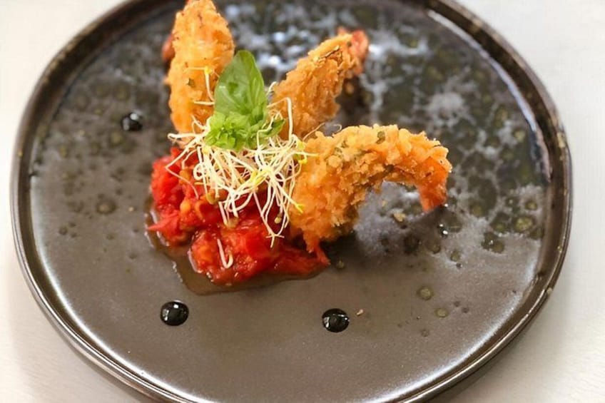 A plate with a food item, possibly a seafood dish, garnished with a green leaf and sprouts. 5