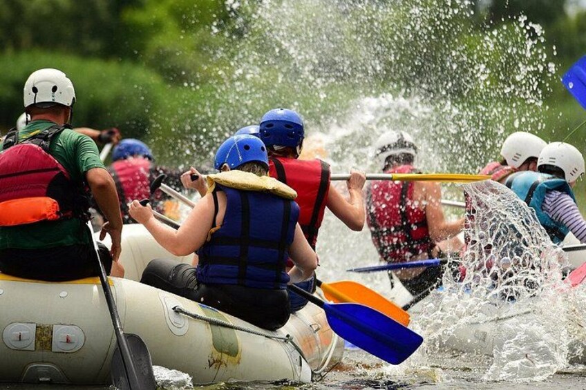 Un grupo de personas en una balsa navegando sobre el agua, usando chalecos salvavidas y cascos. 4