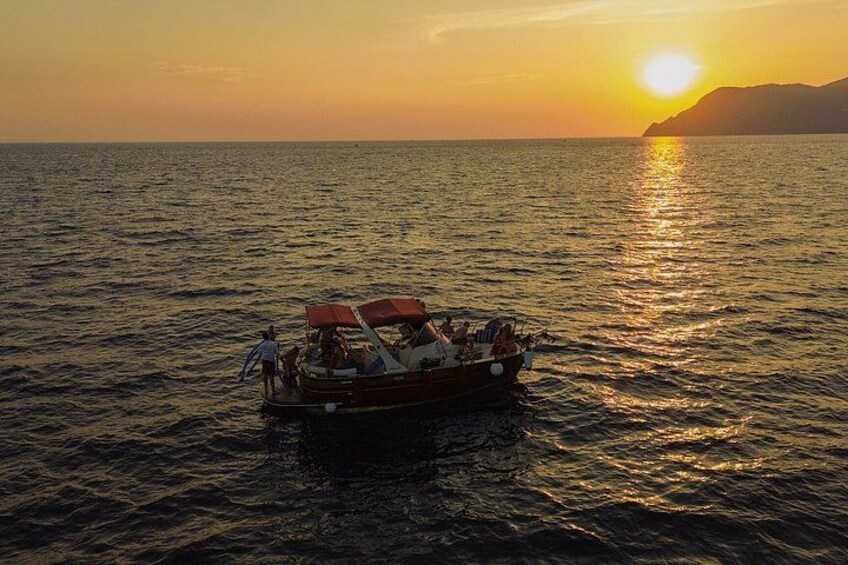 Una barca sull'acqua calma al tramonto, con cielo sereno. 1