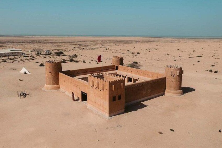 A desert fort with a flag, a tent, and a clear sky. 2