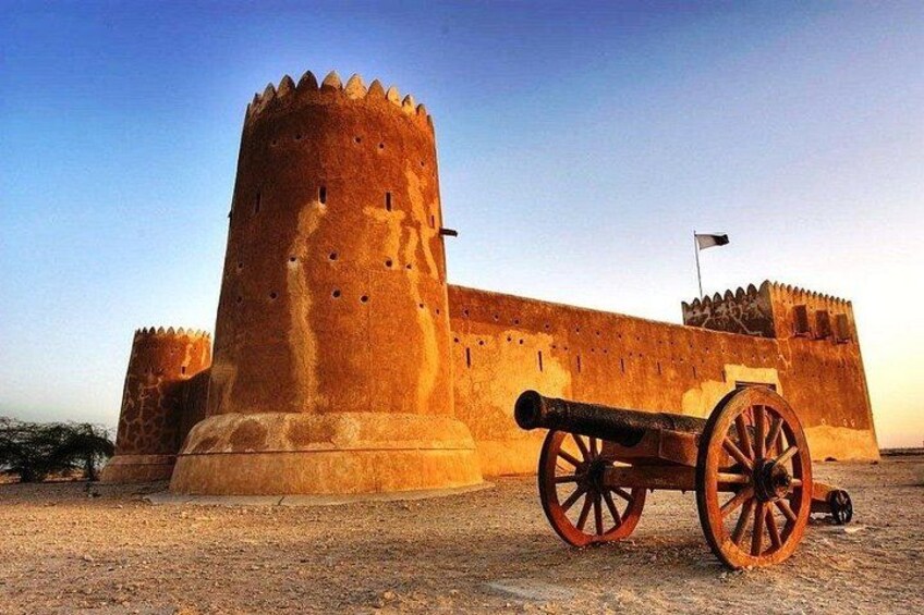 A large, ancient fort with a prominent round tower and a cannon in the foreground. 1