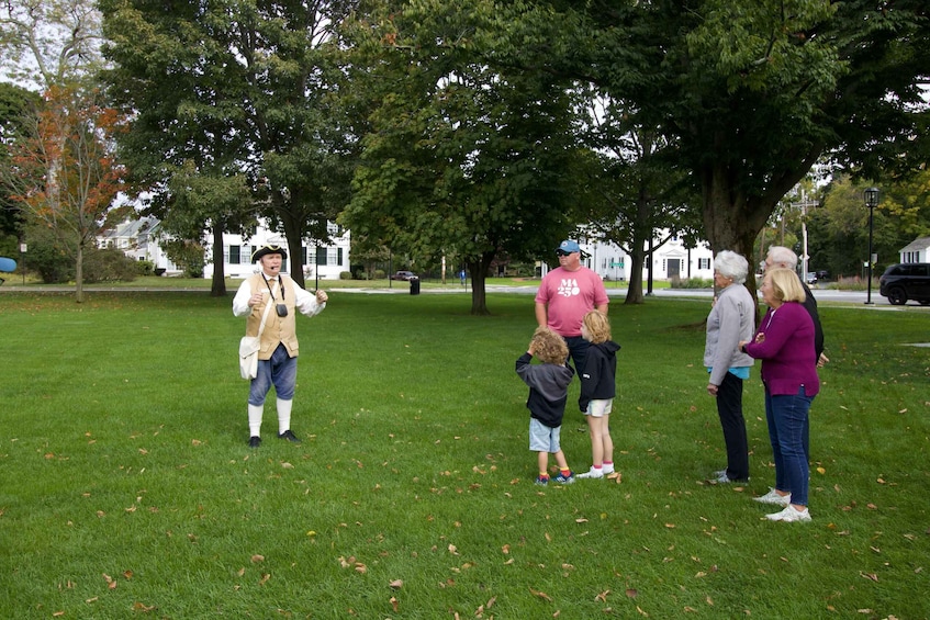 A group of people in a park with trees and grass. 5