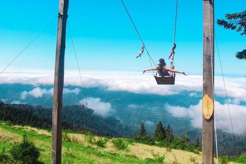 A cable car with passengers, a forested mountain landscape, and a clear sky. 4