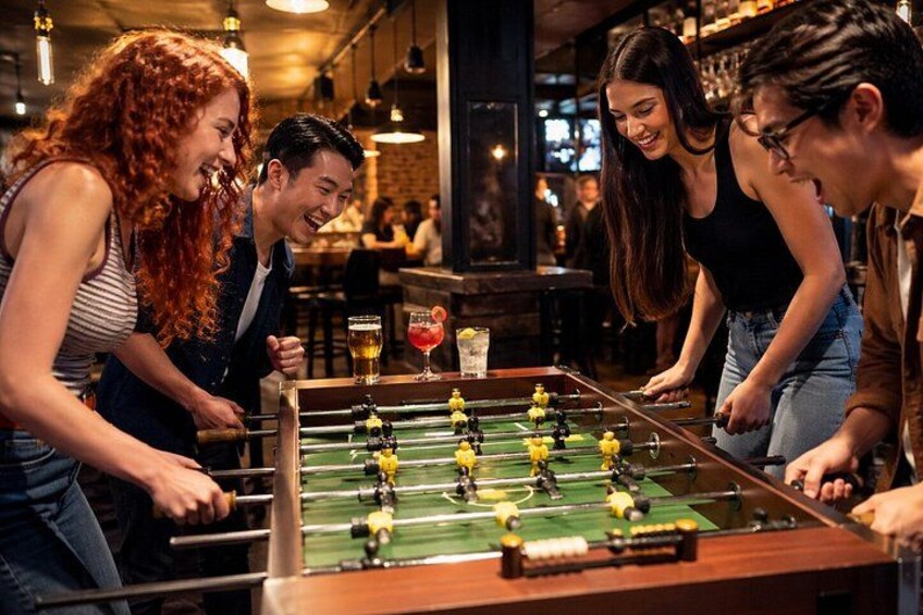 Un tavolo da calcio in un bar, con persone che giocano. 4