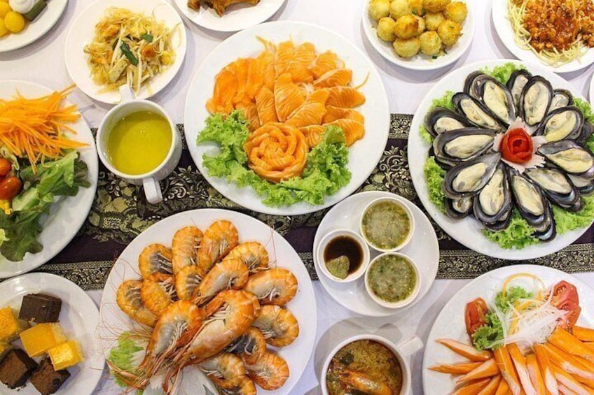 Ett urval av rätter med skaldjur, inklusive räkor, musslor och fisk, som är upplagda på ett bord. 4