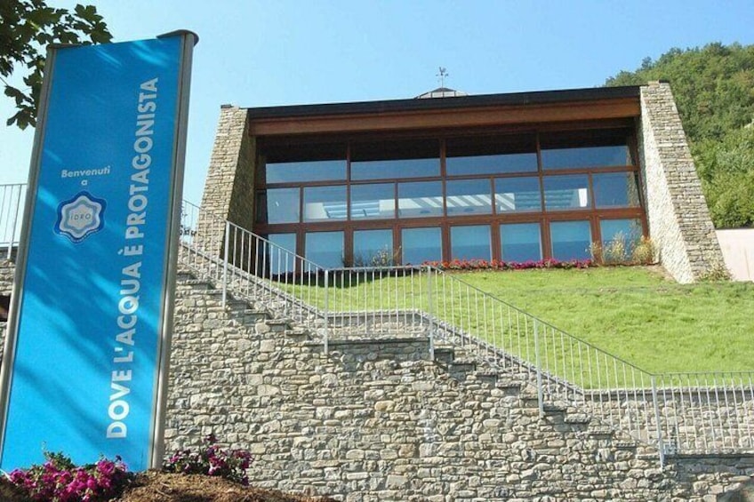 A building with a stone facade, a large glass window, and a blue banner with text. 5
