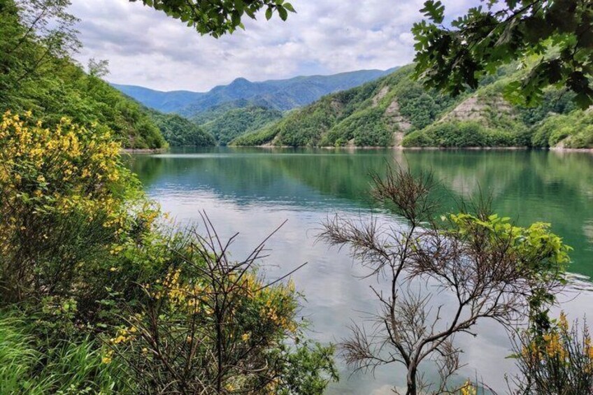 A calm lake surrounded by lush greenery and hills. 5