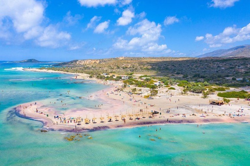 Una spiaggia costiera con acque turchesi cristalline, spiagge sabbiose e un paesaggio collinare sullo sfondo. 4