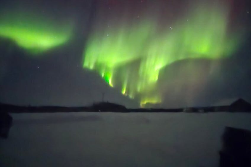Het Noorderlicht boven een besneeuwd landschap met bergen op de achtergrond. 2