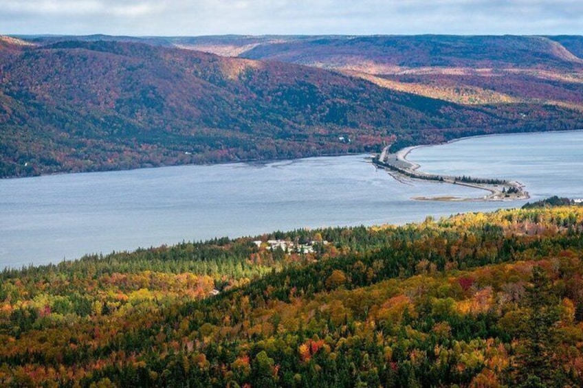A coastal landscape with autumn foliage, a bay, and a small settlement. 3