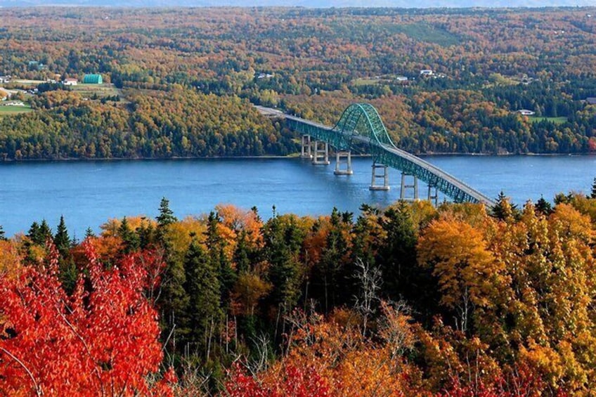 A green bridge over a lake surrounded by autumn foliage. 2