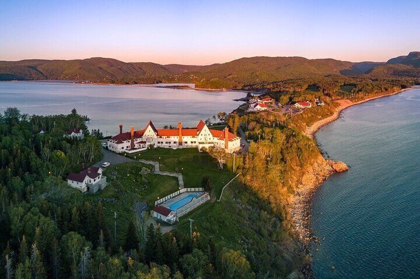 A large estate by a lake with a swimming pool, surrounded by forest and hills. 4
