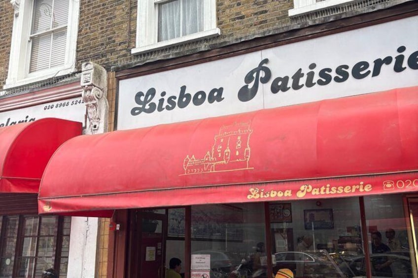 A storefront with a red awning and the name 'Lisboa Patisserie' on the sign. 2