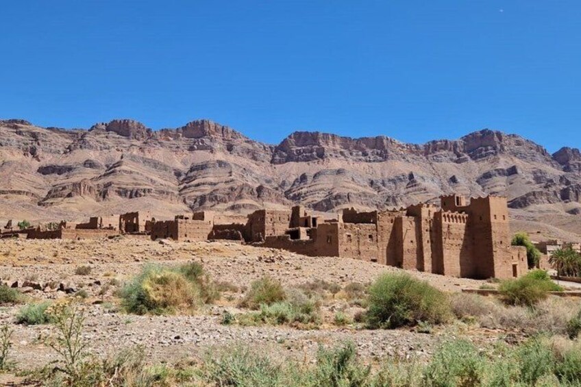 A desert landscape with ancient ruins and mountains in the background. 4