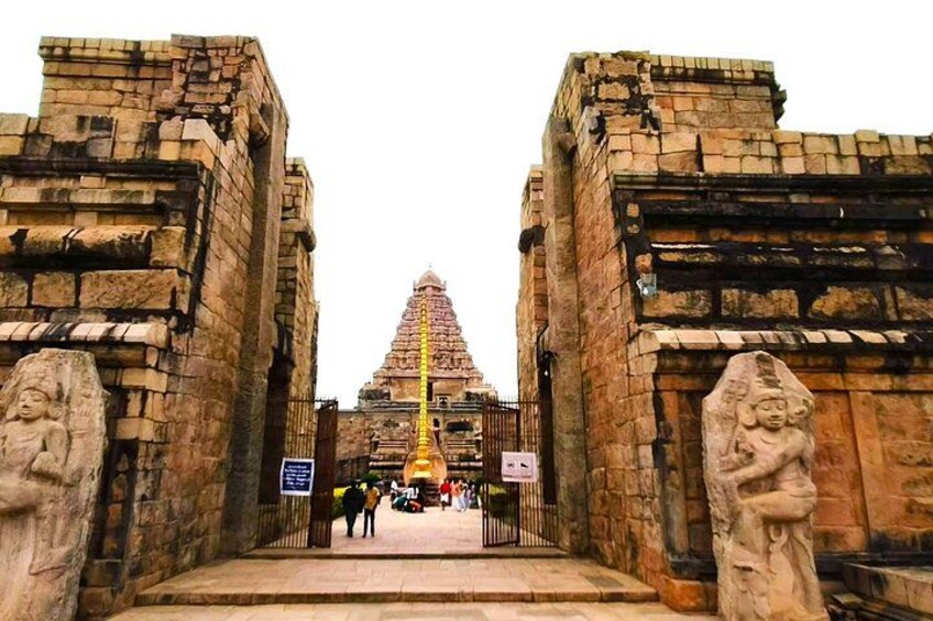 Una entrada antigua a un templo con esculturas de piedra y una aguja central. 4