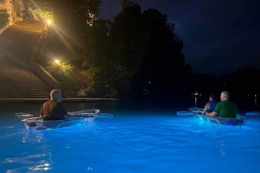 Dos personas en un bote en una piscina iluminada por la noche. 4