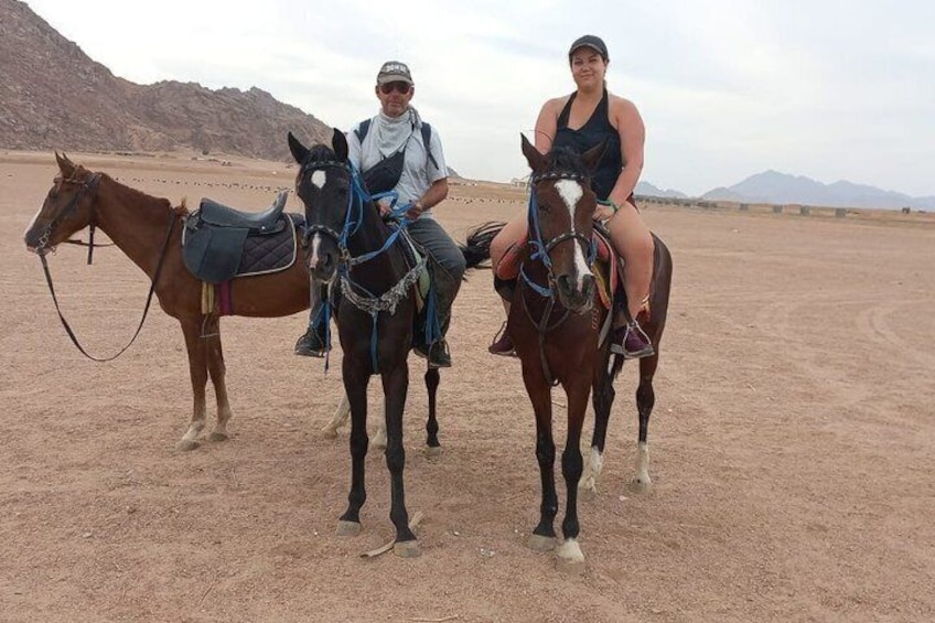 Dos personas montando a caballo en un paisaje desértico con montañas al fondo. 5