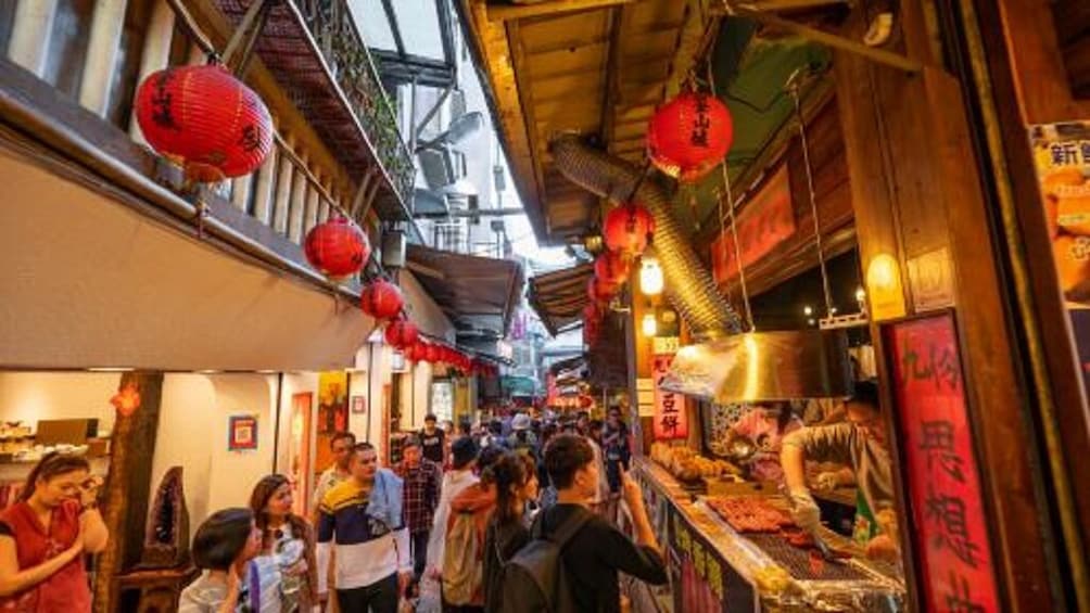 A bustling market street with red lanterns and traditional wooden architecture. 5