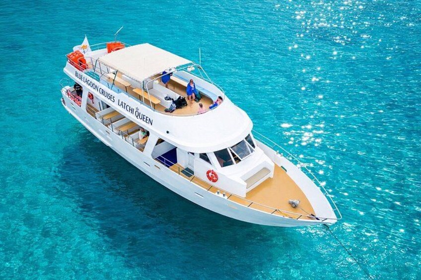 A white cruise ship named 'Blue Lagoon Cruises Latchi Queen' on turquoise water. 1