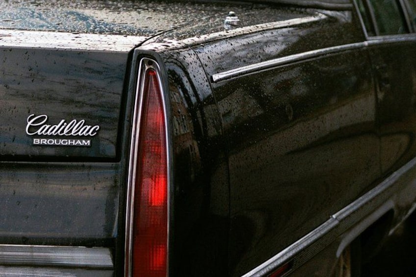 A black Cadillac with the 'Cadillac Brougham' logo on the rear. 1